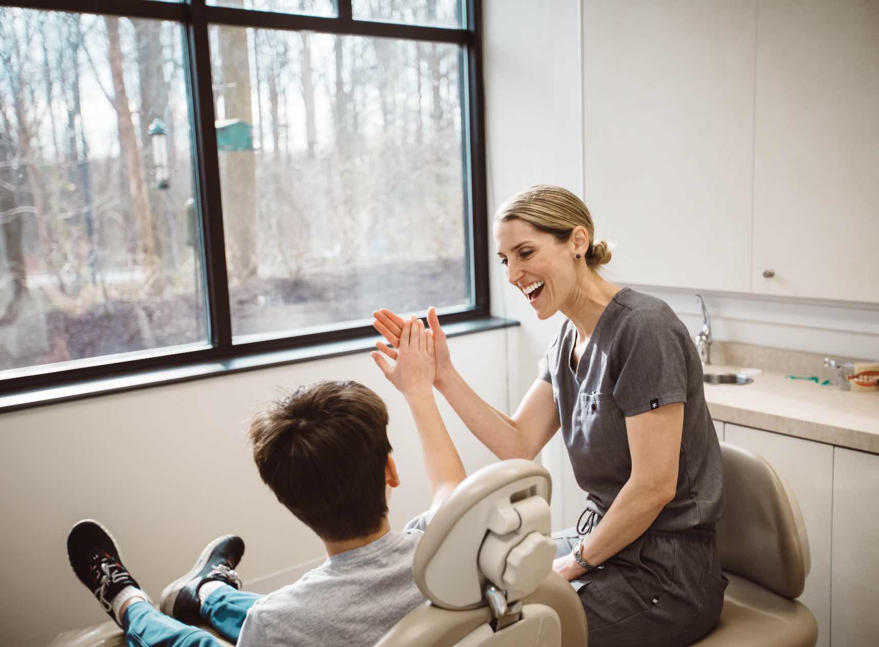 A Woodside hygienist giving a patient a high-five