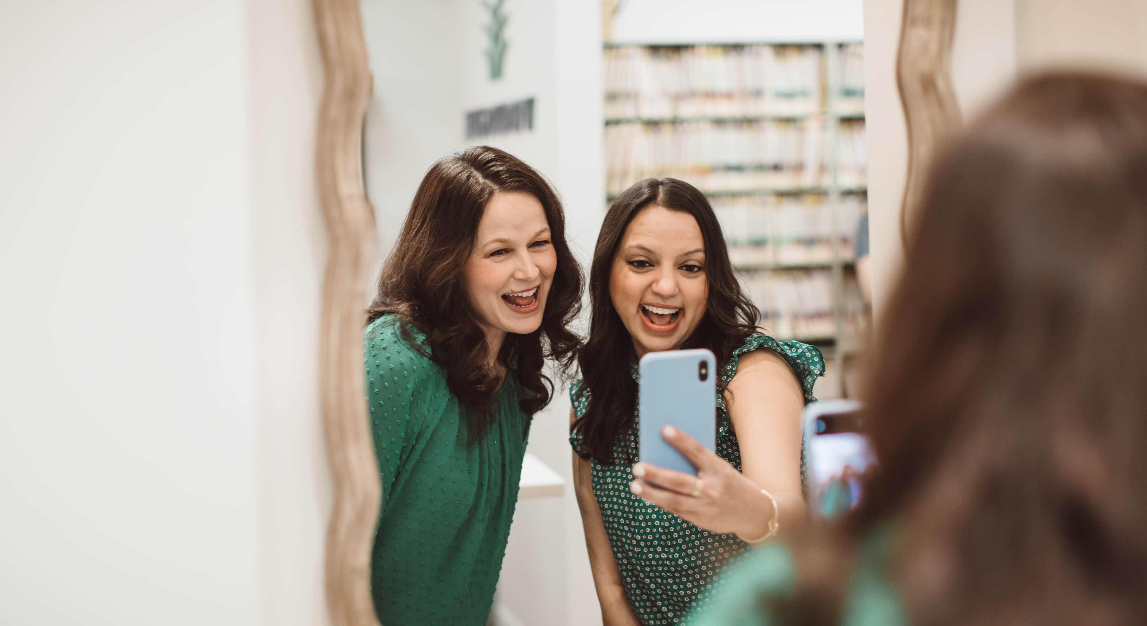 Photo of Dr. Shah and a patient taking a picture in the mirror smiling